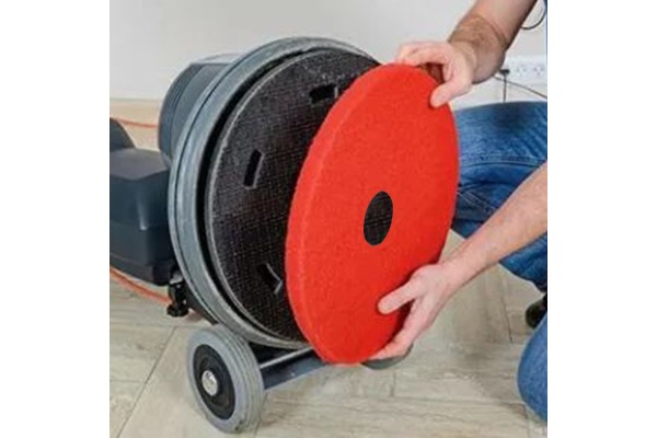 Colocación de disco color rojo en máquina de fregado de suelo