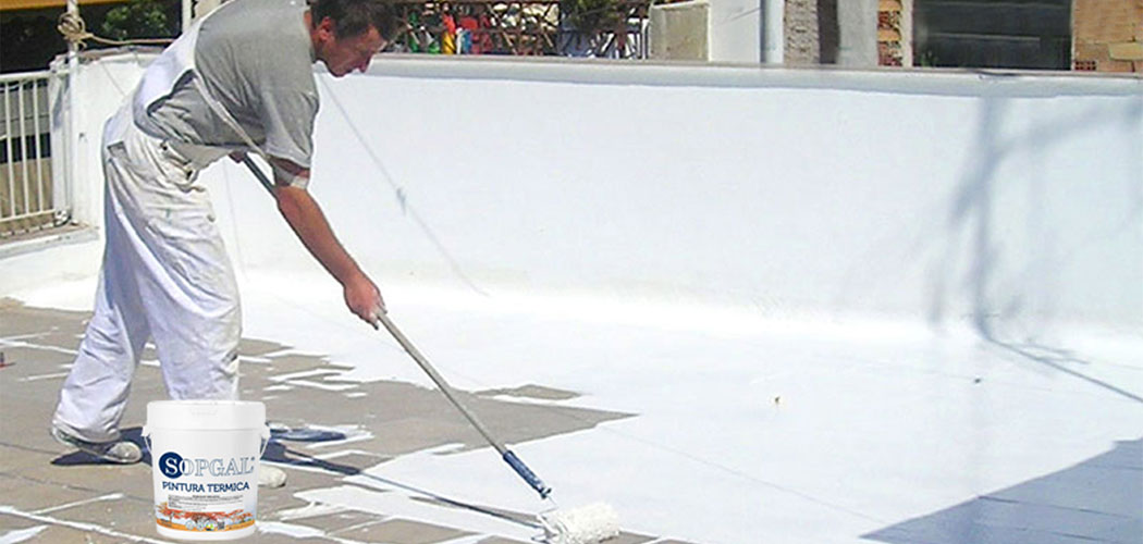 Aplicación de pintura térmica blanca sobre el suelo de una terraza.